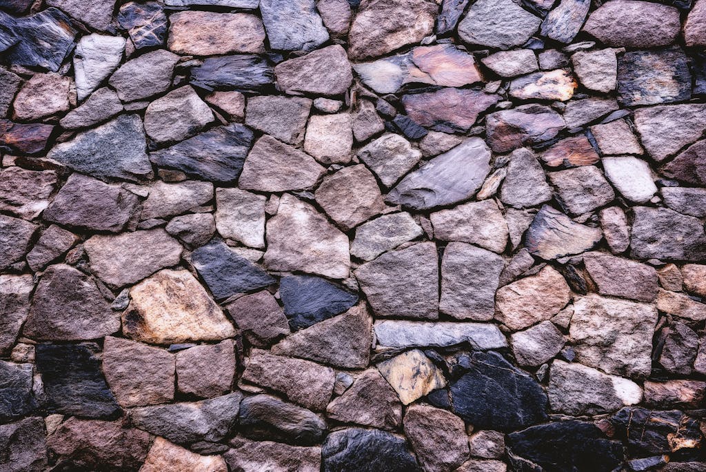 High-resolution image of a rustic stone wall showing detailed texture and pattern.